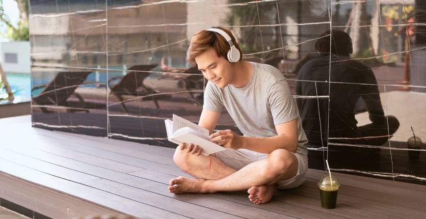 Booktok man reading a book outdoors